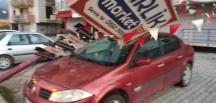 Hatay’da fırtınada reklam direği otomobilin üzerine devrildi