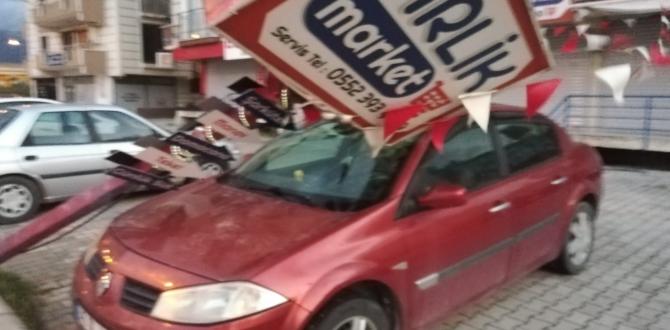Hatay’da fırtınada reklam direği otomobilin üzerine devrildi