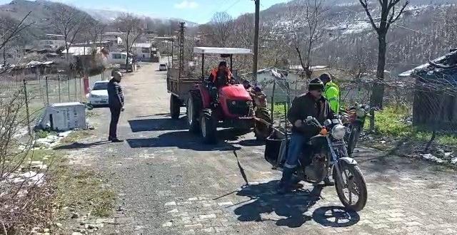Yolda kalan traktörü motosiklet ile çektiler